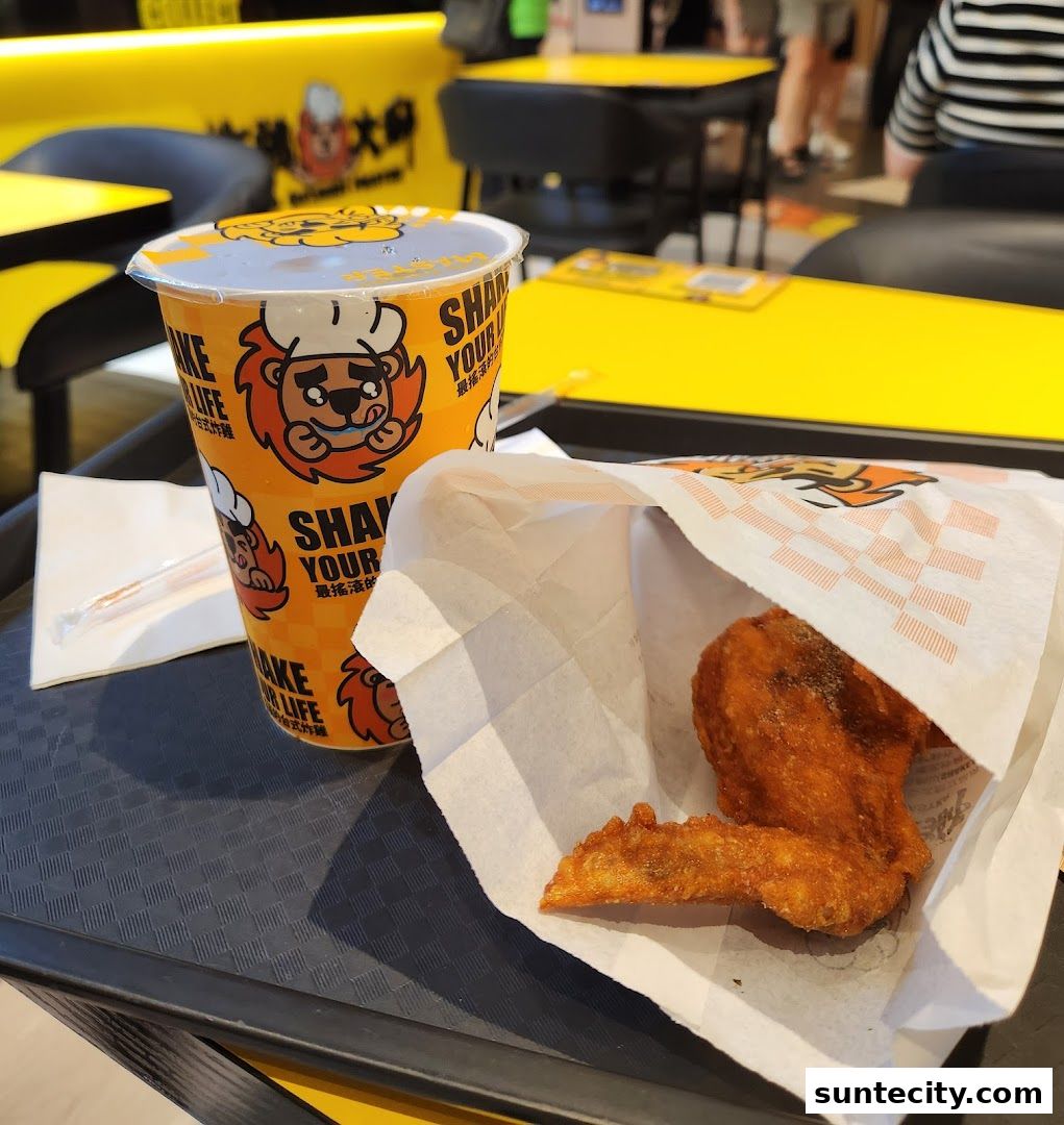 A cup and fried chicken wings on a tray at Fried Chicken Master.