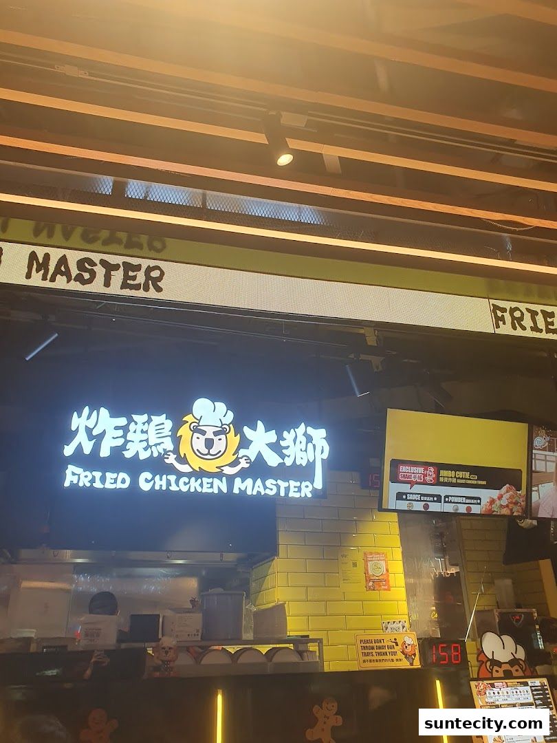 The illuminated sign for Fried Chicken Master with a lion logo above the counter.