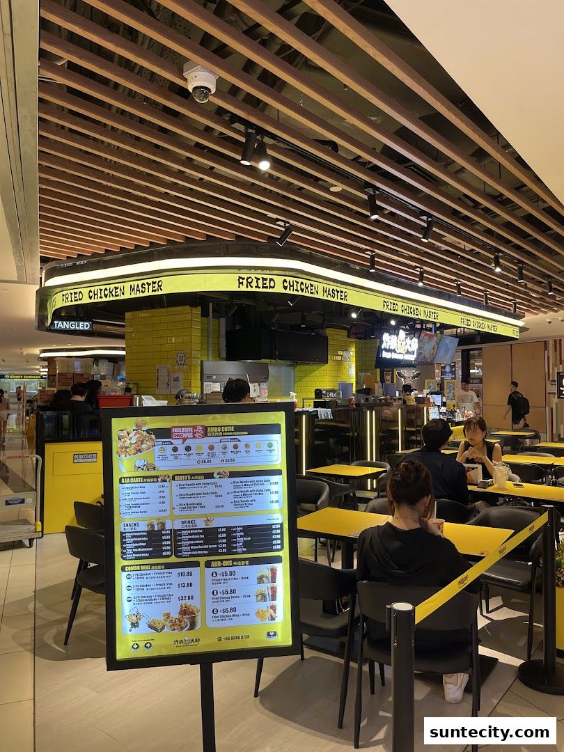 A brightly lit Fried Chicken Master restaurant with yellow tables and a menu board.