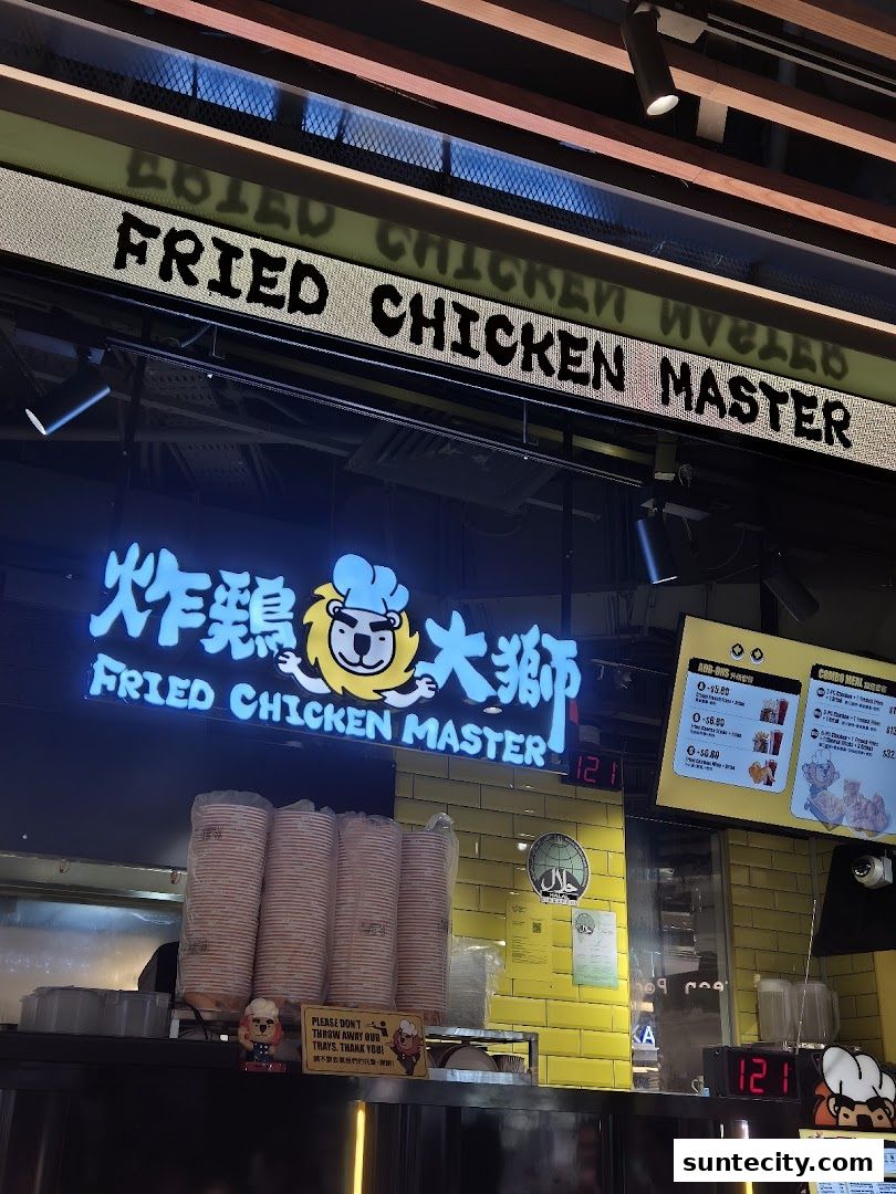 The exterior of Fried Chicken Master with its prominent neon sign and menu boards.