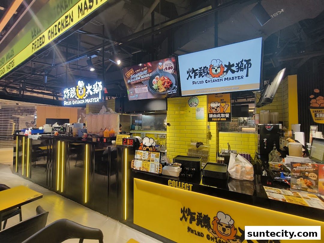 The counter and signage of a Fried Chicken Master shop with bright yellow accents.