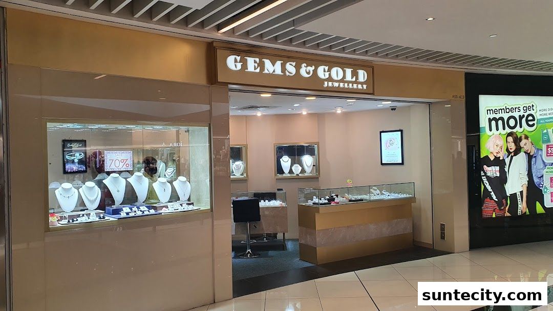 The exterior of a jewelry store called Gems & Gold Jewellery, showcasing necklaces and rings in display cases.