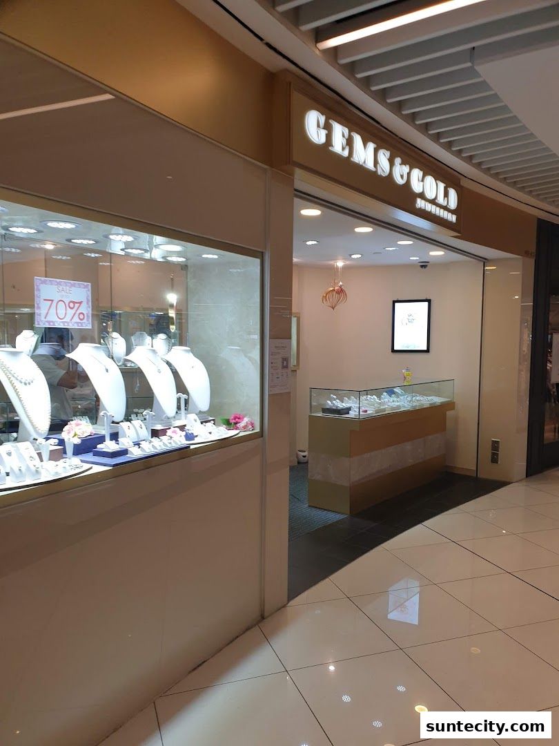 Gems & Gold Jewellery shop front with display cases showcasing necklaces and rings.
