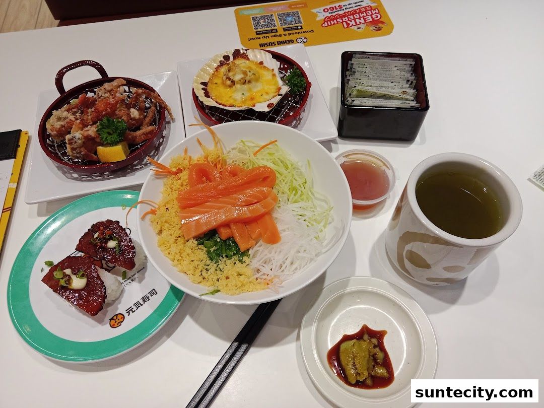 A table filled with various Japanese dishes, including sushi, fried crab, and a bowl of salmon and rice.