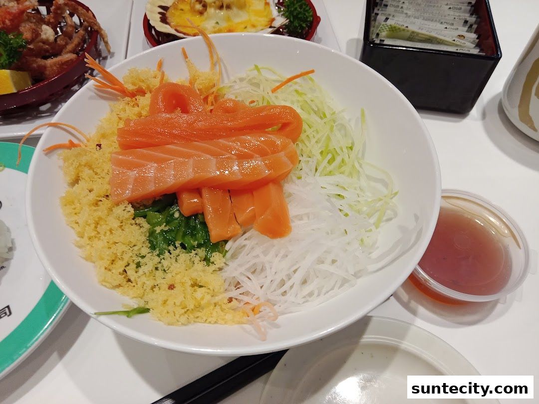 A bowl of salmon sashimi salad with shredded vegetables and crispy tempura bits.