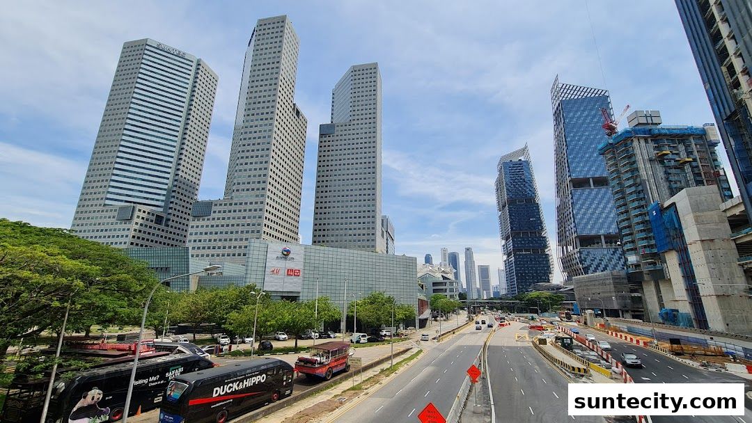 A wide shot of the Suntec City mall and surrounding skyscrapers under a cloudy sky.