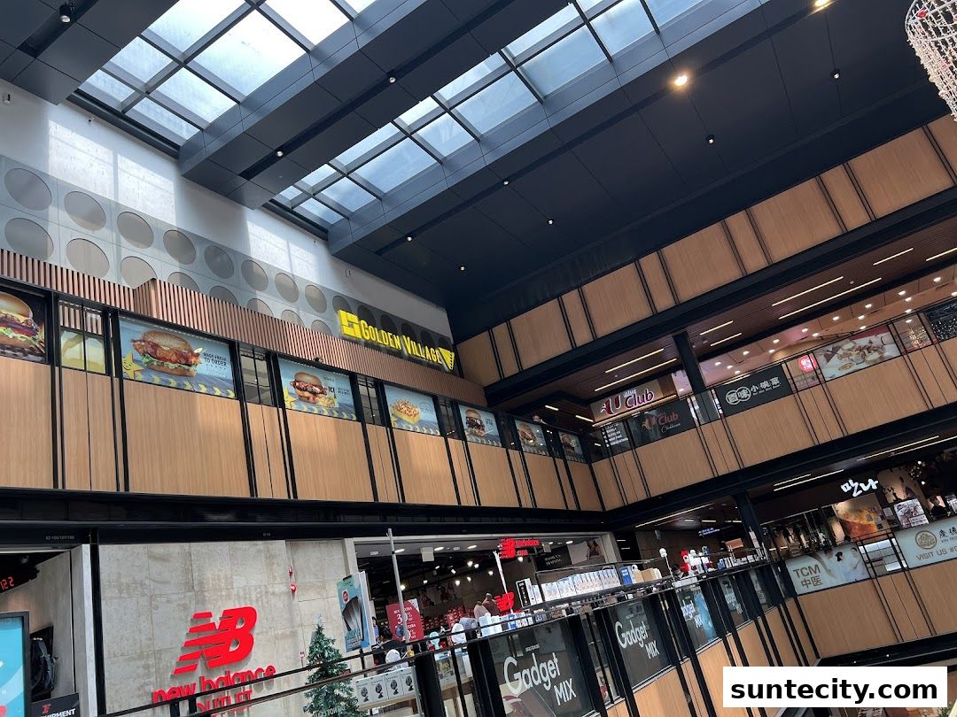 Interior view of a shopping mall with various shops and escalators visible.