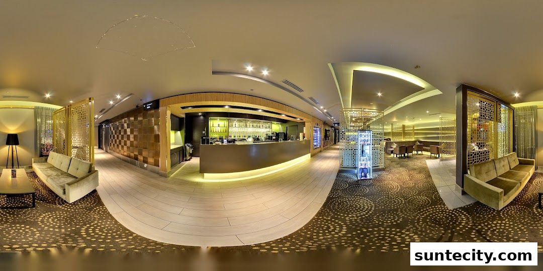 A panoramic view of a stylish lounge area with a bar, seating, and decorative screens.