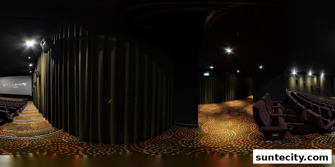 Interior view of a cinema hall with plush seating and a patterned carpet.