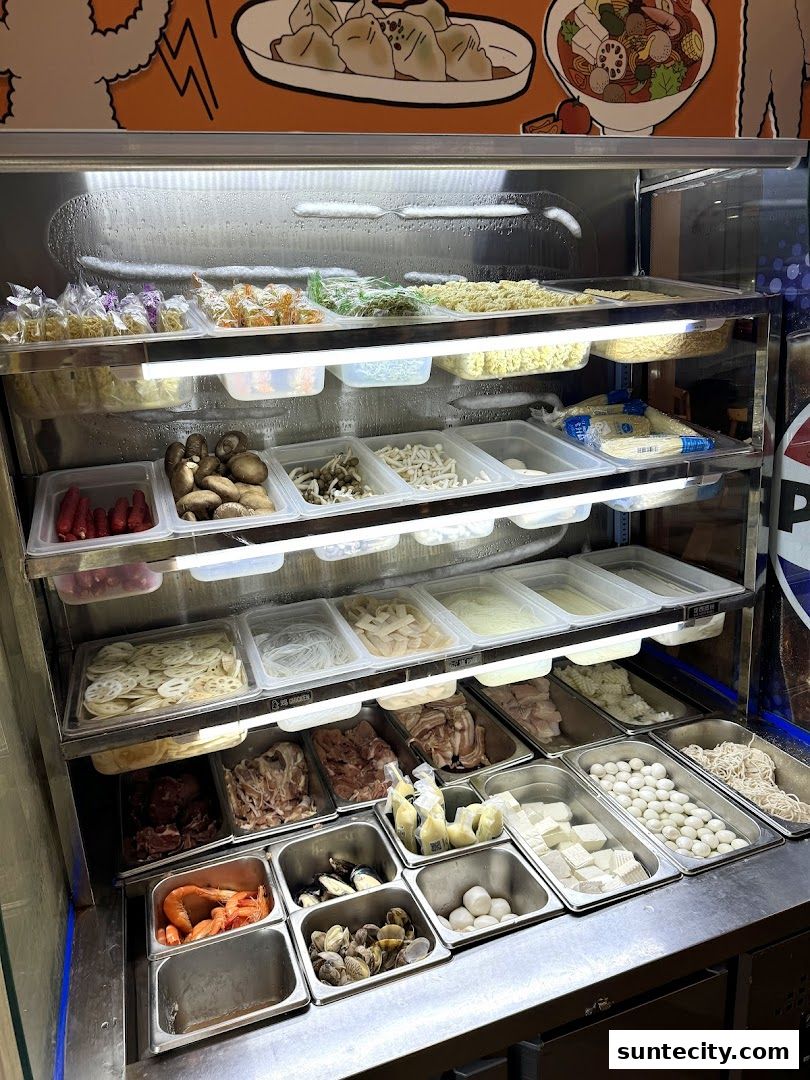 A display case filled with various ingredients for Mala Tang, including meats, vegetables, and seafood.