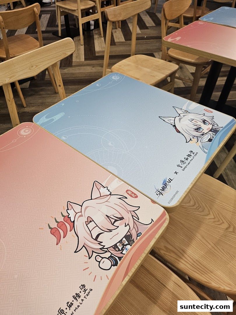 Tables at Gong Yuan Ma La Tang decorated with anime characters and chili peppers.
