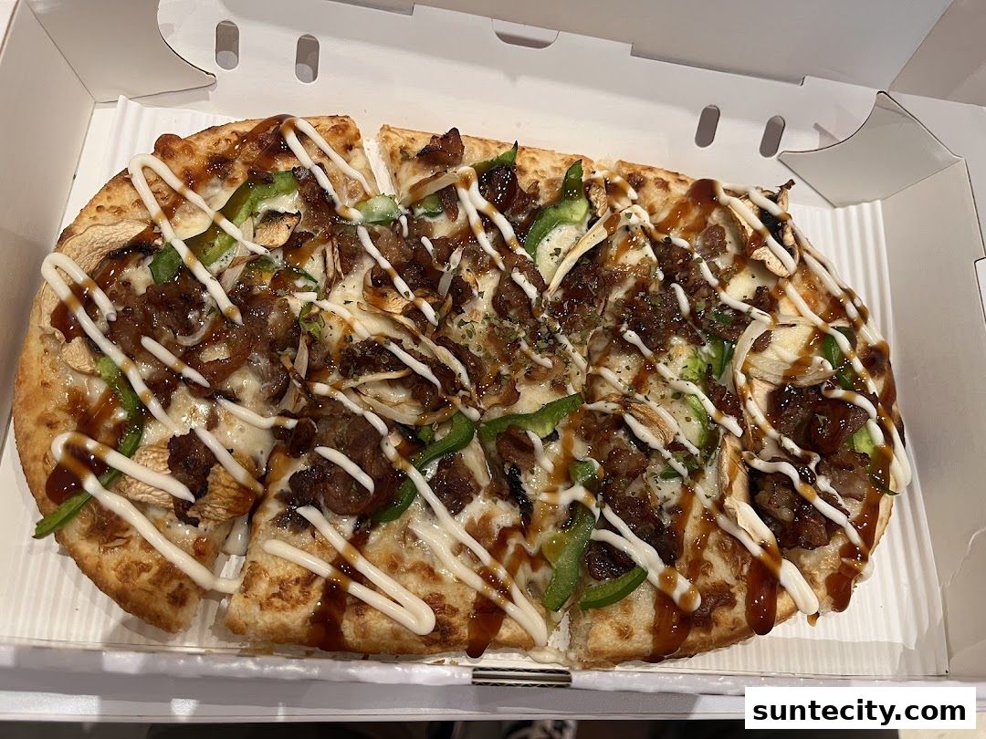 A delicious-looking pizza with various toppings and sauces in a white box.