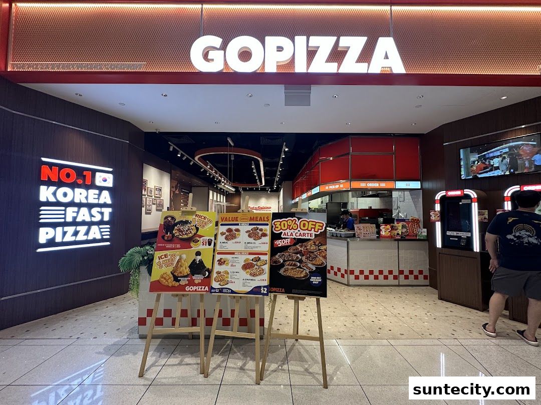 The entrance of GOPIZZA Suntec City, featuring promotional posters and the restaurant's signage.
