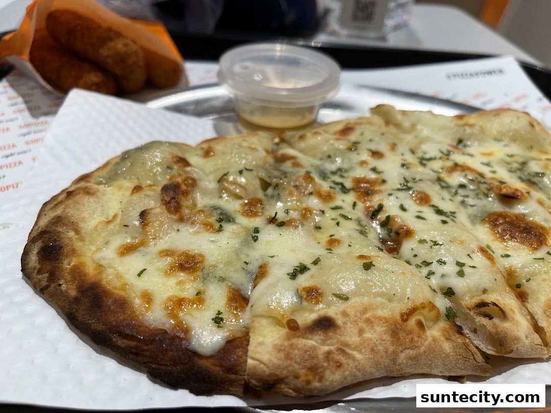 A close-up of a delicious cheese pizza with a side of fried snacks.