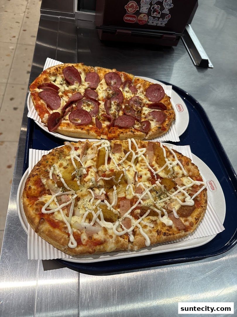 Two delicious pizzas, one with pepperoni and the other with ham and pineapple, on a tray.