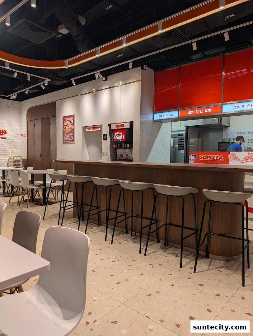 Interior view of GOPIZZA Suntec City with seating, counter, and kitchen area visible.