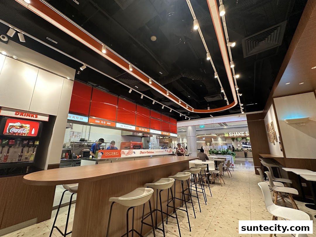 Interior view of GOPIZZA Suntec City with a counter, seating, and kitchen area.