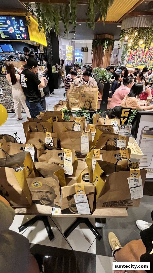A busy Guzman y Gomez restaurant with many takeaway bags and customers dining.