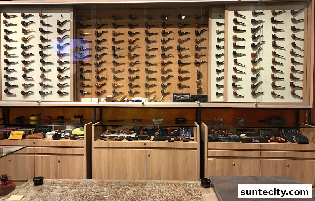 A well-lit display of numerous smoking pipes arranged on shelves and in cabinets.