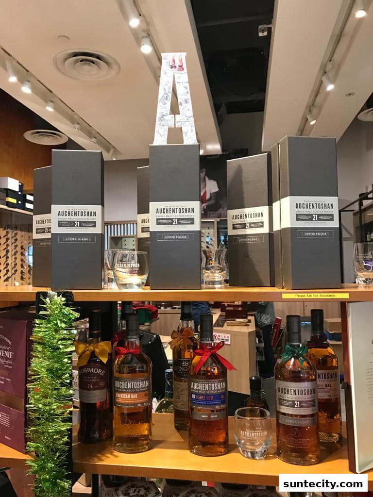 A display of Auchentoshan whisky bottles and gift boxes, with a decorative letter 'A'.