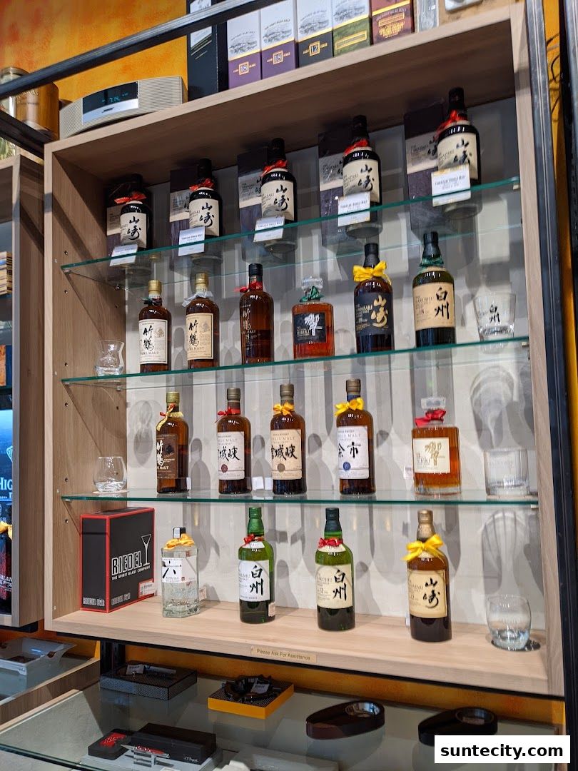 A display shelf filled with various bottles of Japanese whisky and glassware.