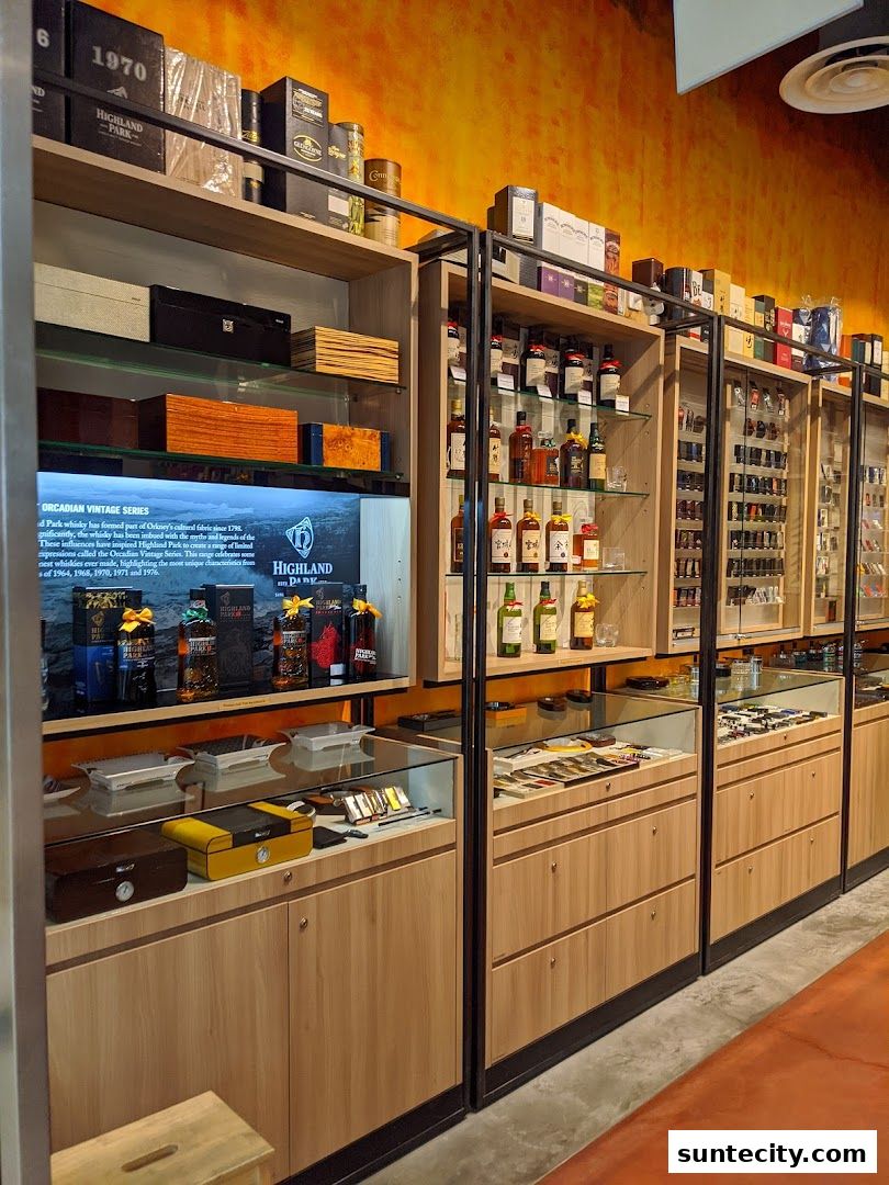 Shelves stocked with bottles of spirits, boxes, and accessories in a retail store.