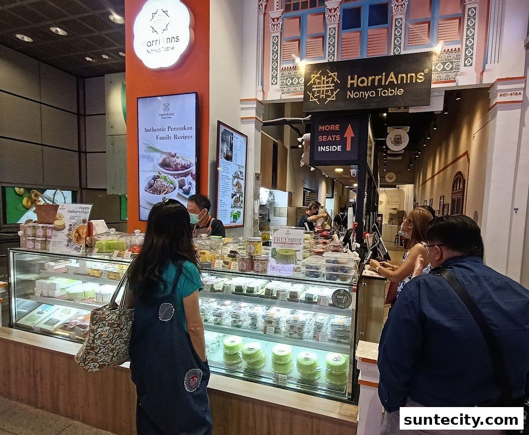 Customers browsing a display of Peranakan desserts and food at HarriAnns Nonya Table.