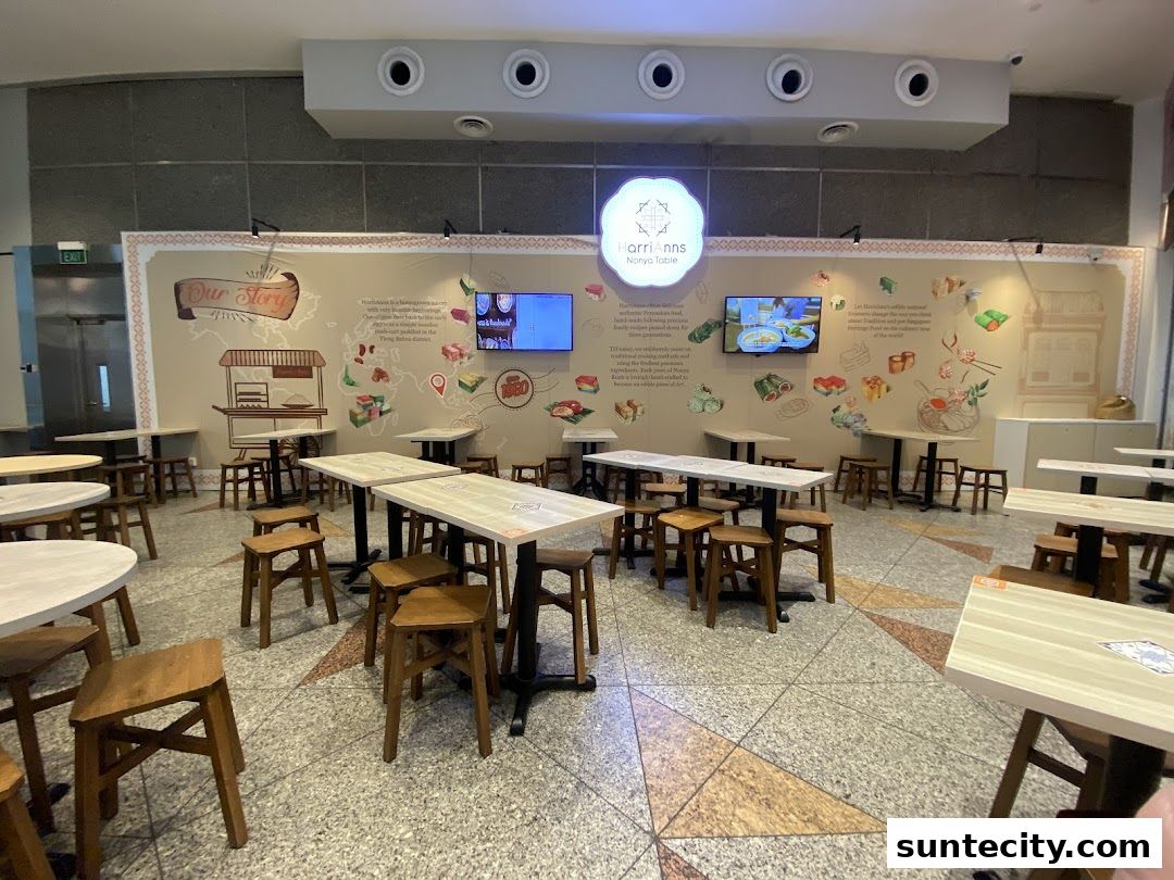 Interior of HarriAnns Nonya Table restaurant with tables, chairs, and decorative wall art.