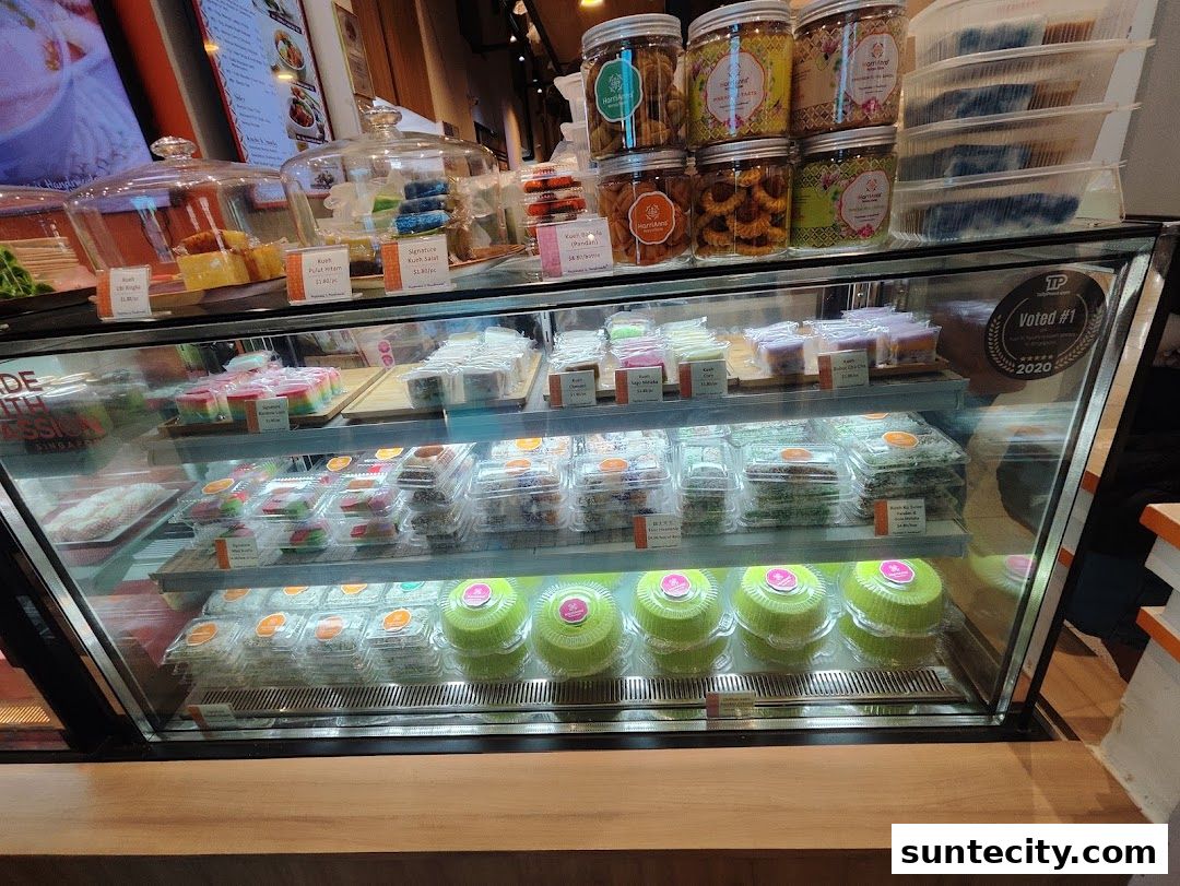 A display case filled with colorful Peranakan kueh and cookies at HarriAnns Nonya Table.