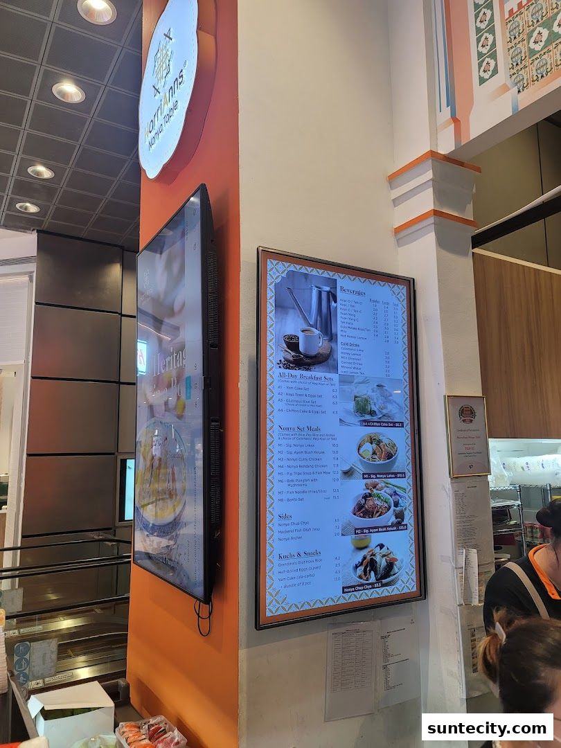 A digital menu board displaying Nonya cuisine and beverages at HarriAnns Nonya Table.