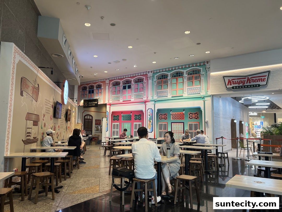 Interior of a dining area with people seated at tables, featuring colorful Peranakan-style decor.