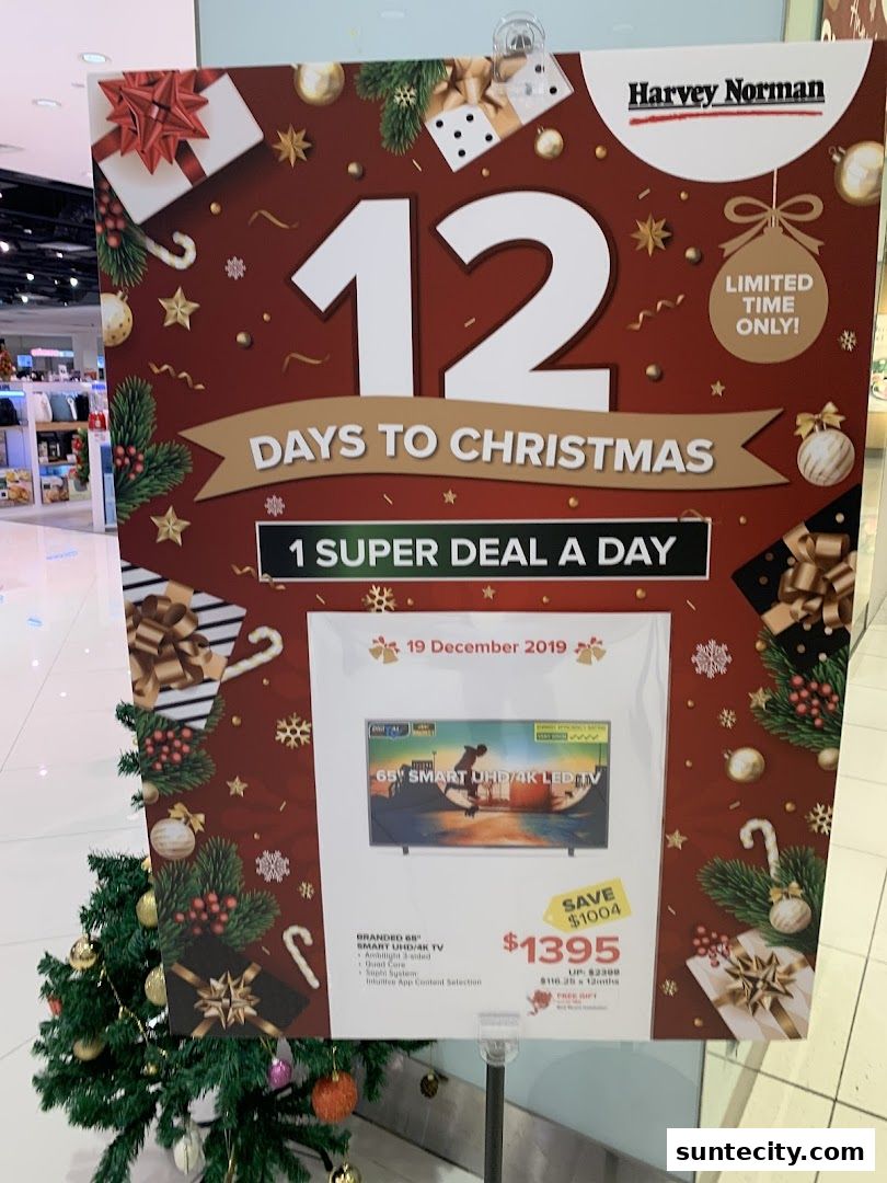 A promotional sign for Harvey Norman's '12 Days to Christmas' event, featuring a TV deal.