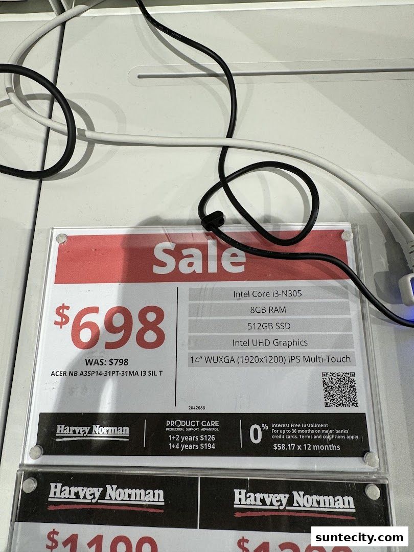 A sale sign for an Acer laptop at Harvey Norman, showing price and specifications.