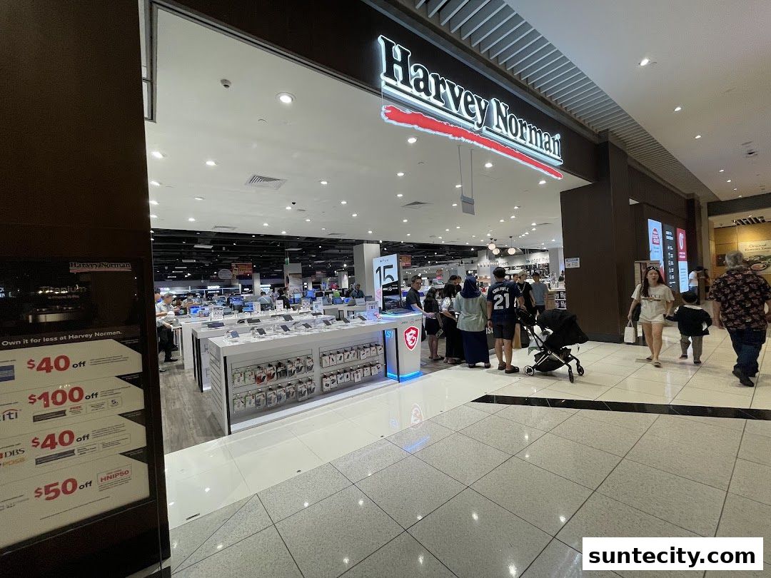 The entrance of Harvey Norman Suntec City, showcasing electronics and promotional offers.