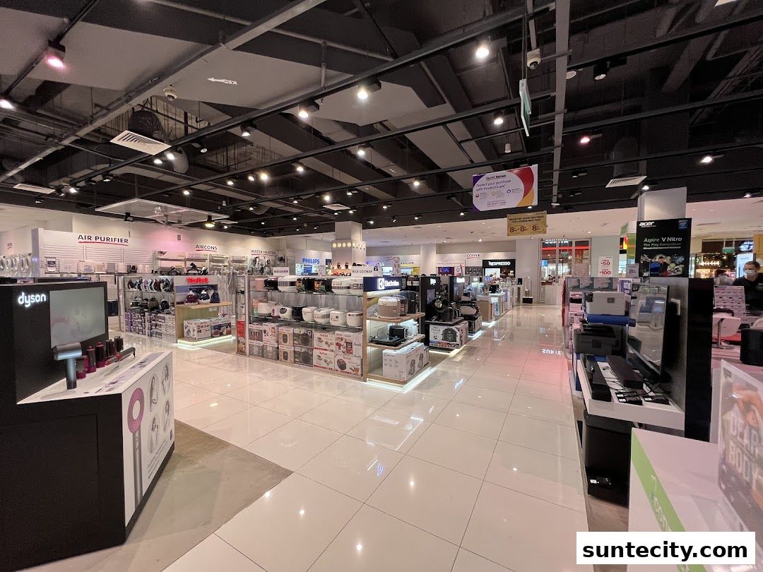 Interior view of a well-lit electronics and home appliance store with various products on display.