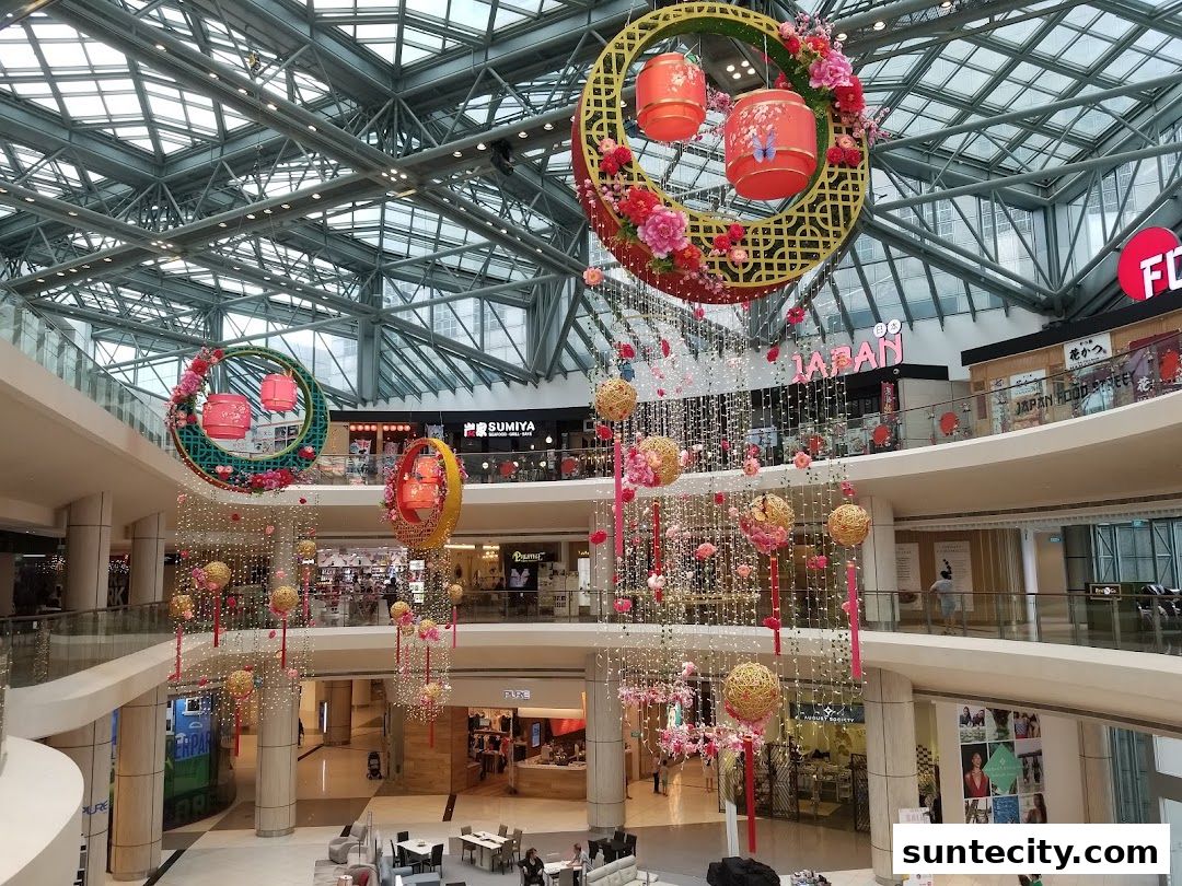 Interior view of a shopping mall with festive decorations and various shops on multiple levels.