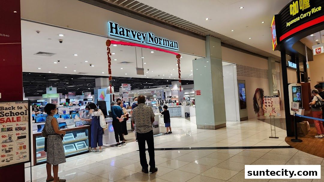The entrance of Harvey Norman Suntec City, showcasing electronics and a 'Back to School Sale'.