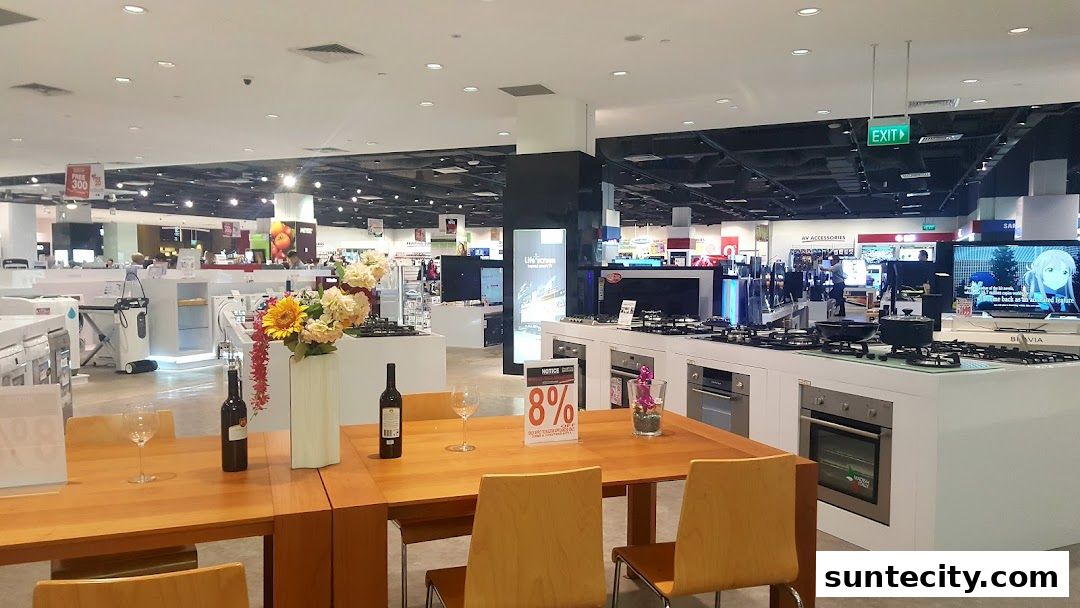 Interior view of a large electronics and home appliance store with kitchen appliances on display.