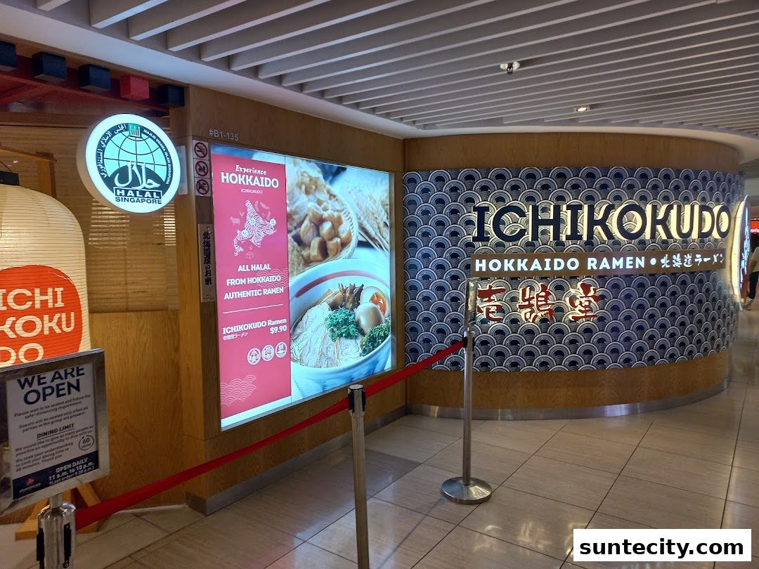 The exterior of Ichikokudo Hokkaido Ramen shop with a large illuminated menu and signage.