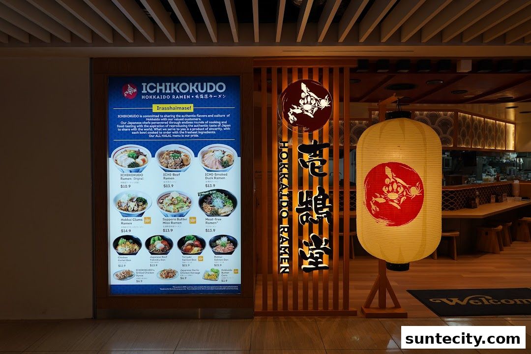 The entrance of Ichikokudo Hokkaido Ramen, featuring a illuminated menu and a large lantern.