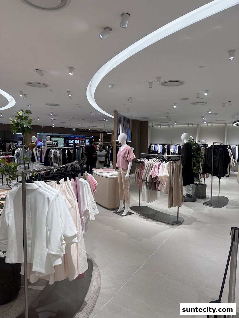 Interior view of a clothing store with mannequins and racks of apparel.