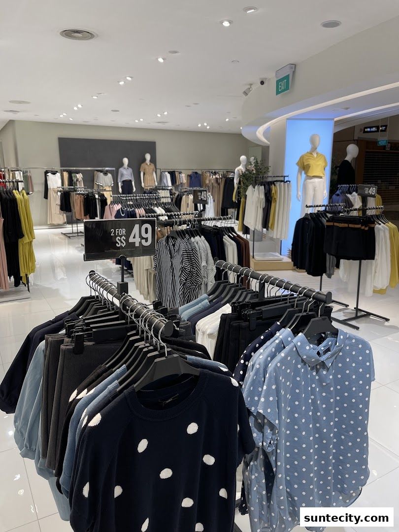 A well-lit clothing store interior with racks of women's apparel and mannequins.