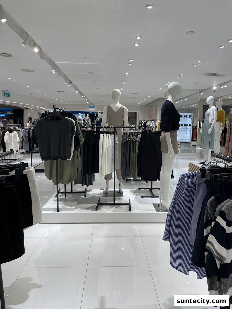 Interior view of a clothing store with mannequins displaying outfits and racks of clothes.