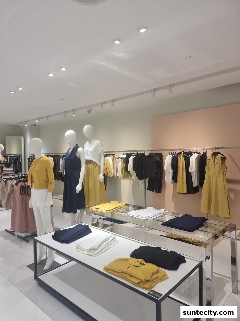 Mannequins display stylish women's clothing in a well-lit retail store.