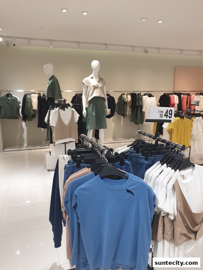 Mannequins and clothing racks display fashionable apparel in a well-lit retail store.