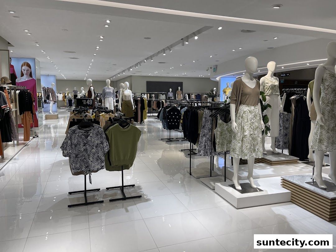 Interior view of a clothing store with mannequins displaying outfits and racks of apparel.