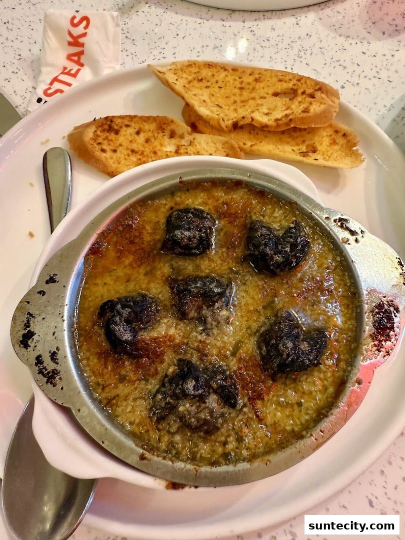 A close-up of escargots in garlic butter served with toasted bread.