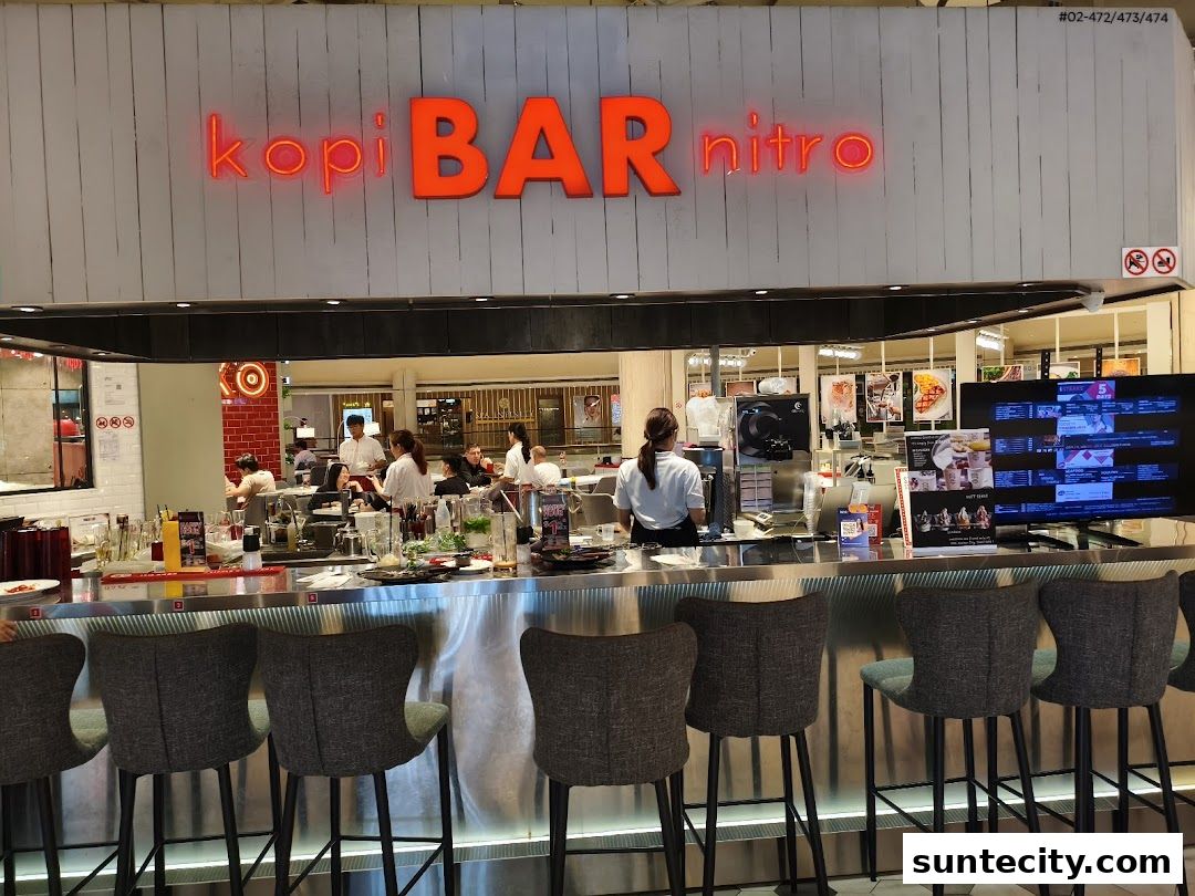 Interior of a modern coffee bar with neon signage and bar seating.