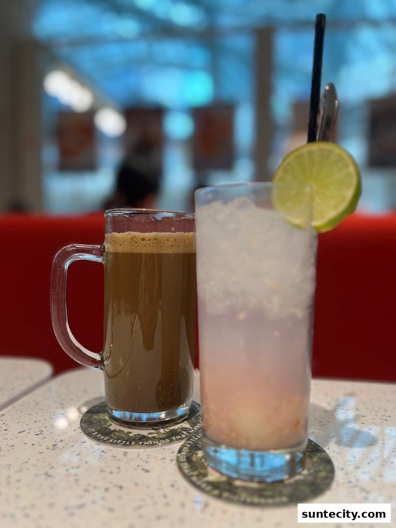 Two refreshing drinks, one coffee and one iced beverage with lime, sit on coasters.
