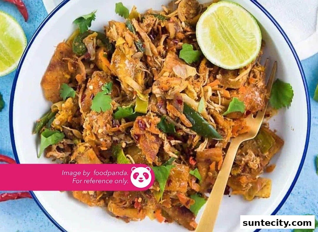 A close-up shot of a delicious-looking prata dish with a lime wedge and fork.